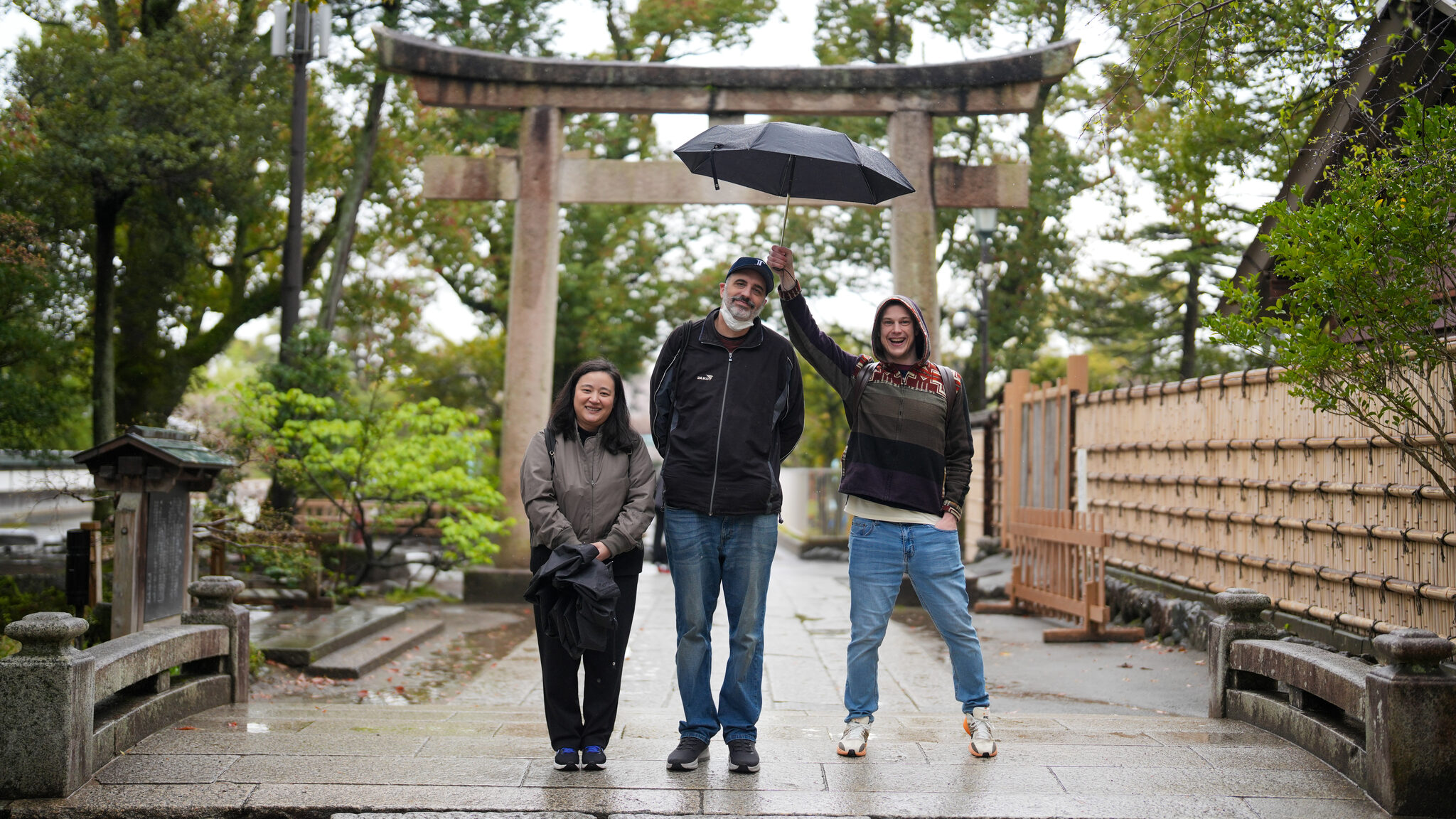 Guests walking through a torii gate on a rainy morning
